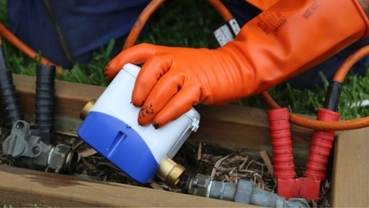 Technician installing a digital water meter outdoors