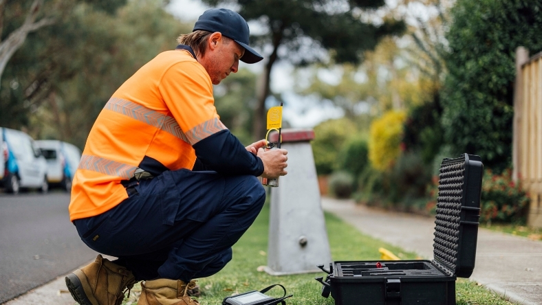 Water utility technician testing network equipment to detect leaks in a residential area