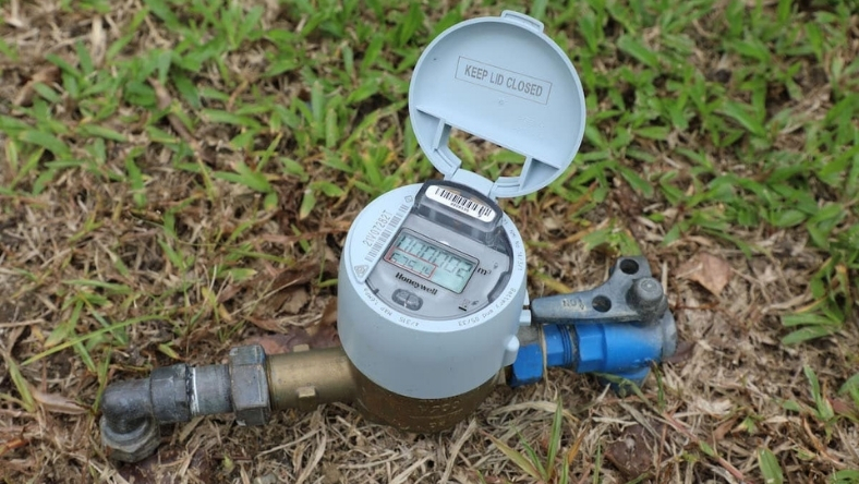 Residential smart water meter installed underground with digital display